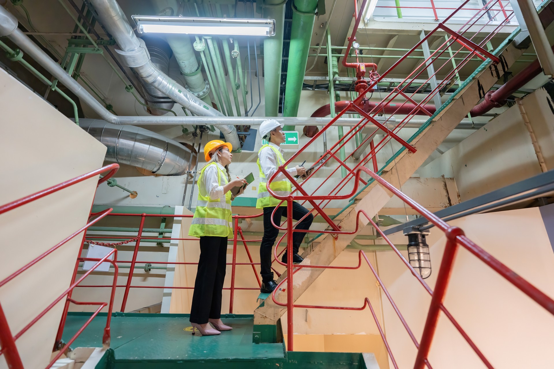 The industrial power plant produces electricity for export to every continent with 2 male and female engineers as part of the process. They supervise and control the machinery in the laboratory.