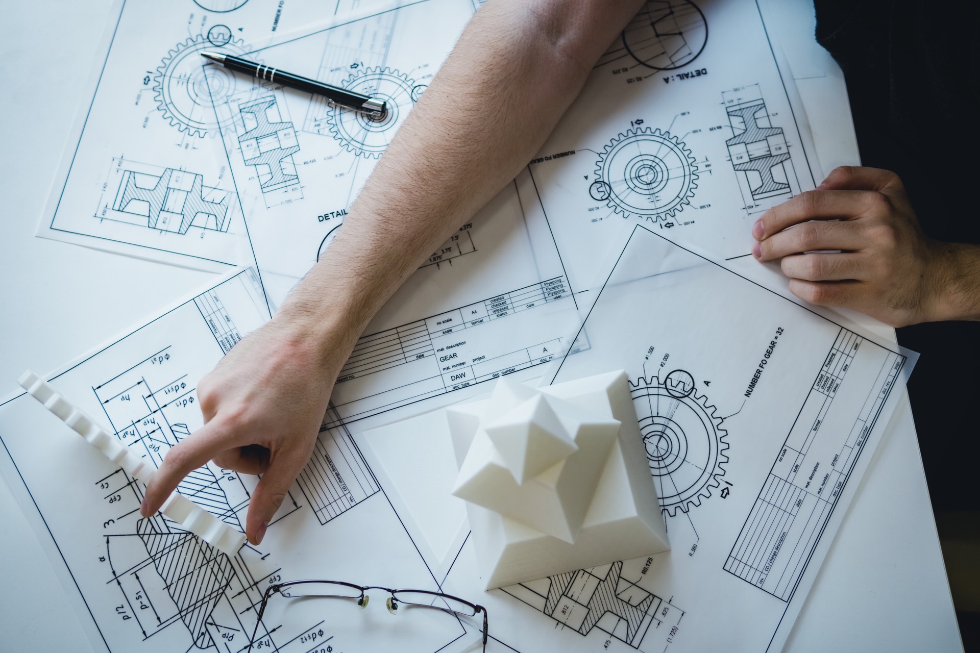 Engineering man's hand working with 3D printer's components and blueprint for designing mechanical parts . Engineering tools and  technology concept.